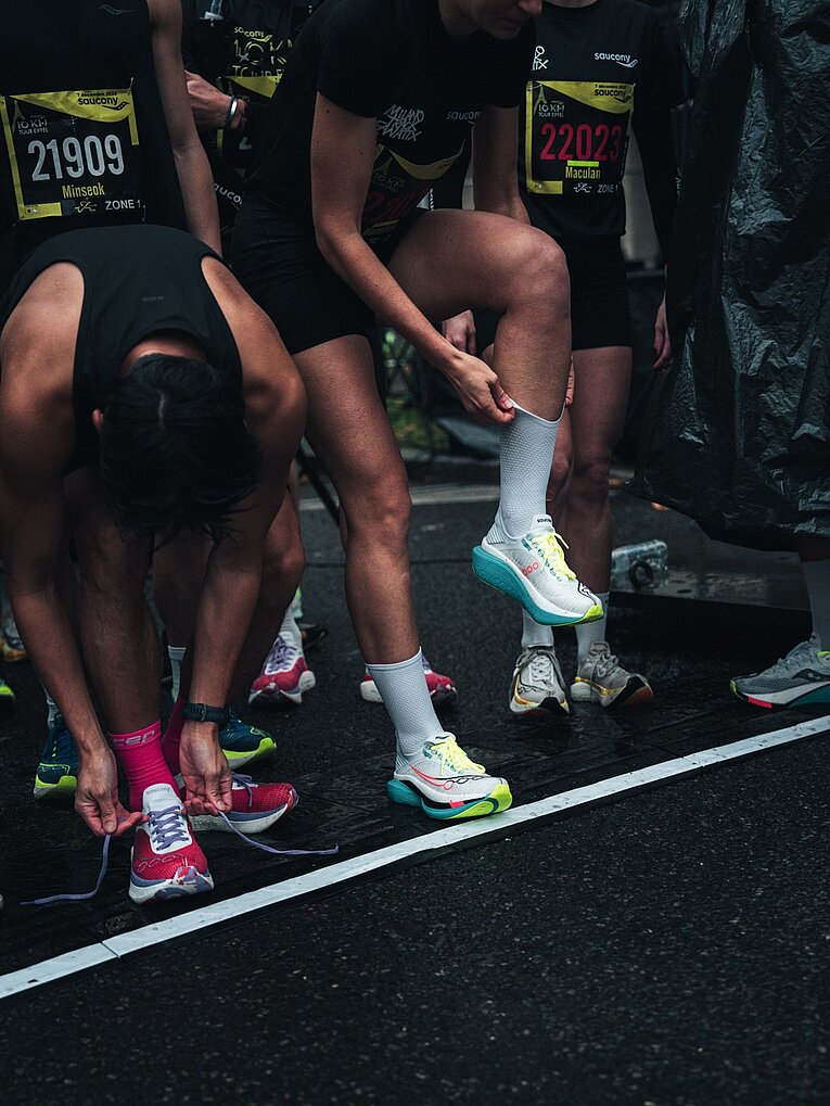 Nahaufnahme von Laufschuhen von Läufern, die an einer Startlinie stehen 