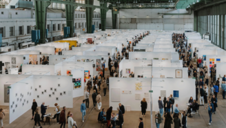 Ausstellungsstände auf der POSITIONS Berlin Art Fair im Hangar des Flughafens Tempelhof mit zahlreichen Besuchern.