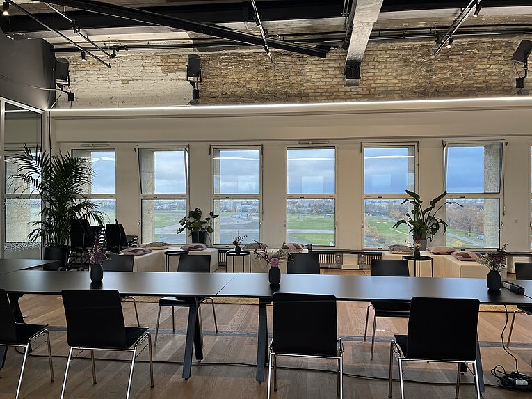 Lange Tafel im THF TOWER am Flughafen Tempelhof. Durch die Fenster kann man auf das Tempelhofer Feld schauen