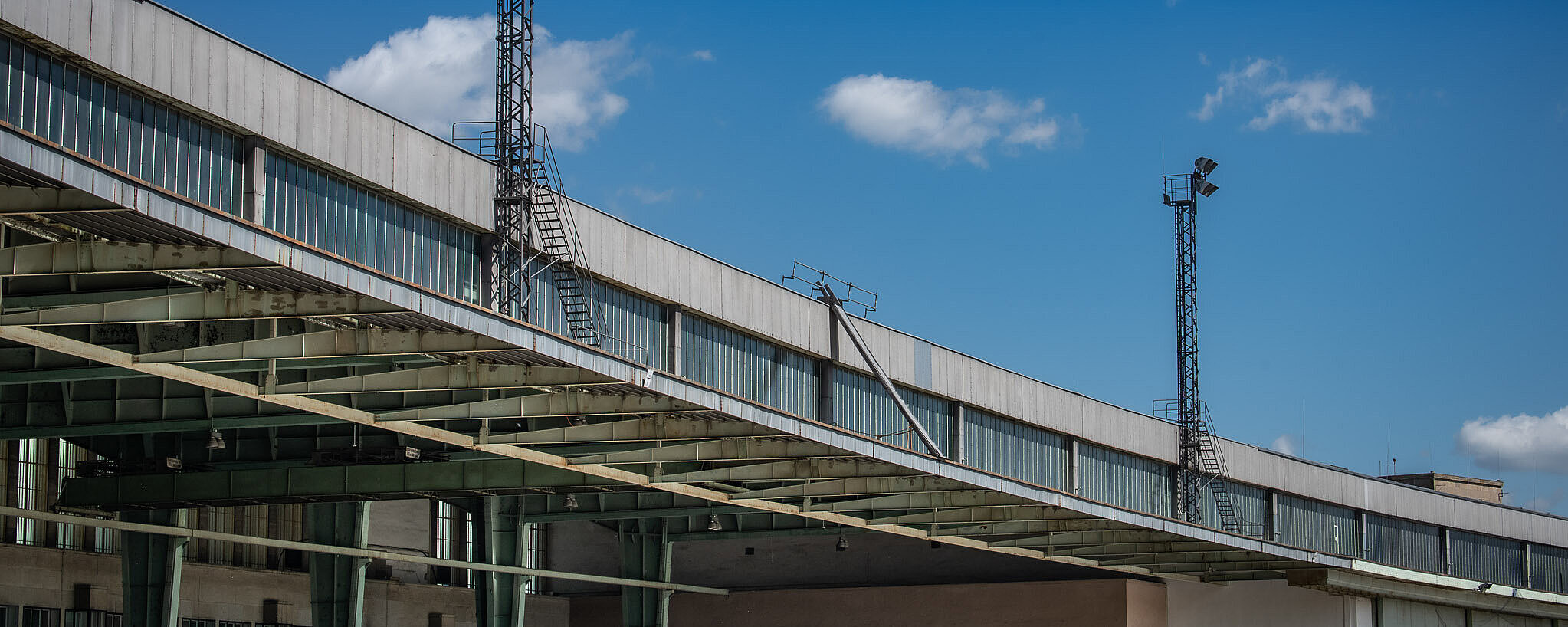 Schwung des Daches über dem Vorfeld, blauer Himmel und kleine weiße Wölkchen