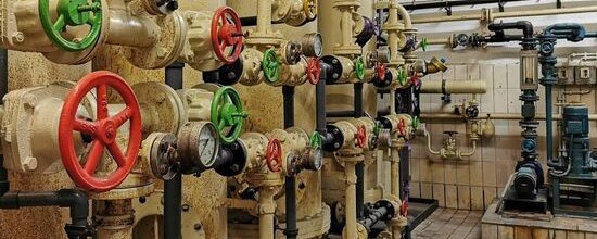 Heizkraftwerk mit verschiedenen Drehschrauben und Anzeigeuhren an den hellen Rohren