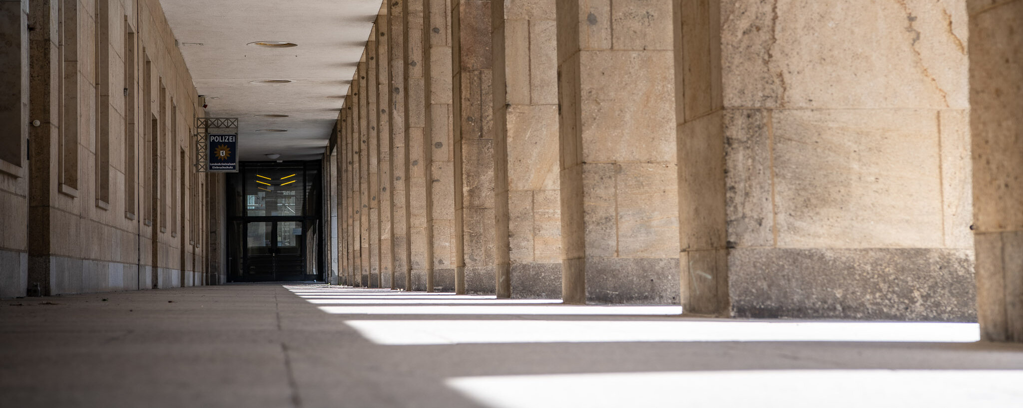 Blick durch einen Arkadengang am Ende ist eine dunkle Tür