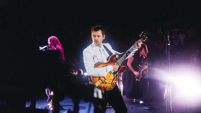 Harry Styles mit Gitarre auf einer Bühne