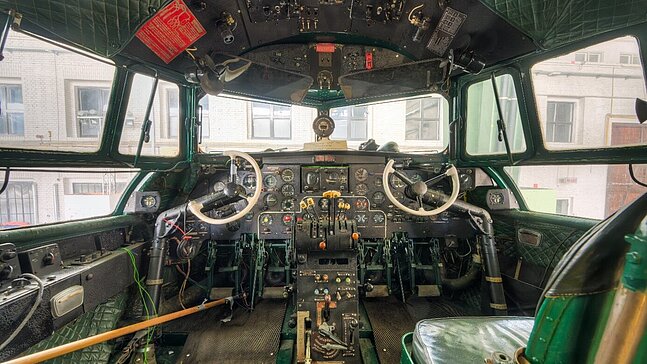 Innensicht des Cockpits des historischen Flugzeugs Iljuschin IL-14P mit grünen Sitzen und grünen Wandverkleidung