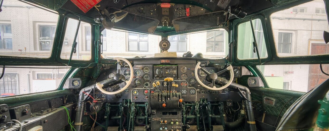 Innensicht des Cockpits des historischen Flugzeugs Iljuschin IL-14P mit grünen Sitzen und grünen Wandverkleidung