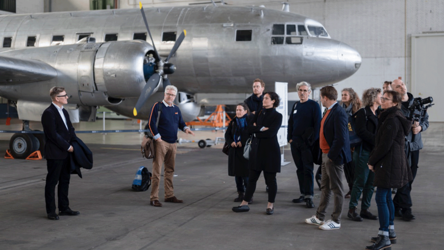 Eine Gruppe von Menschen vor einem historischen Flugzeug im Flughafen tempelhof