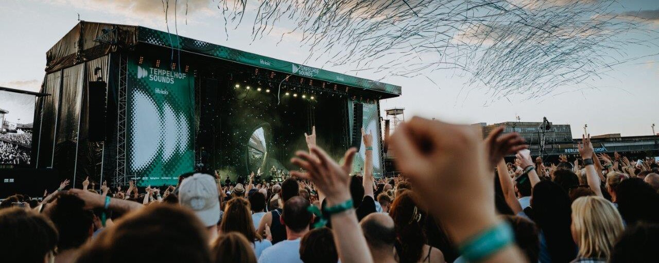 Jubelnde Menschenmenge vor einer Bühne beim Live-Konzert