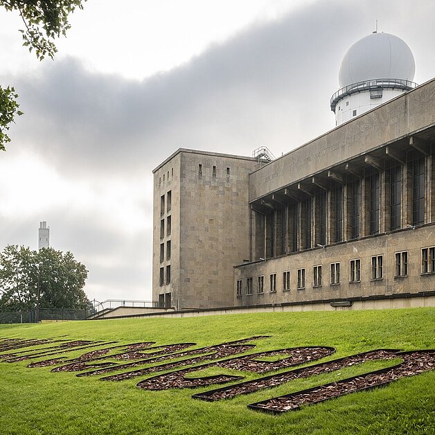 Erinnerungszeichen "Nicht mehr zu Sehen" am Flughafen Tempelhof vor der Flughafen Gebäude. Im Hintergrund der Radarturm