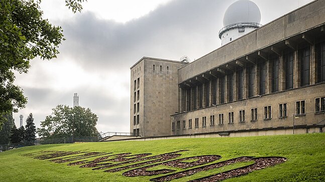 Erinnerungszeichen "Nicht mehr zu Sehen" am Flughafen Tempelhof vor der Flughafen Gebäude. Im Hintergrund der Radarturm