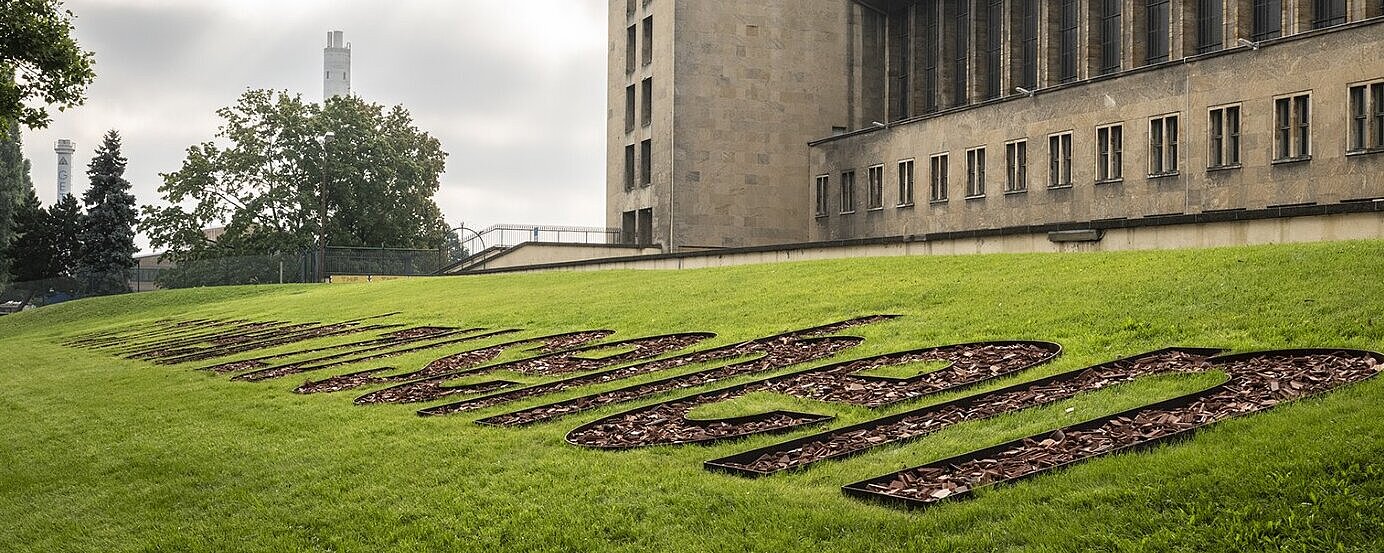 Erinnerungszeichen "Nicht mehr zu Sehen" am Flughafen Tempelhof vor der Flughafen Gebäude. Im Hintergrund der Radarturm