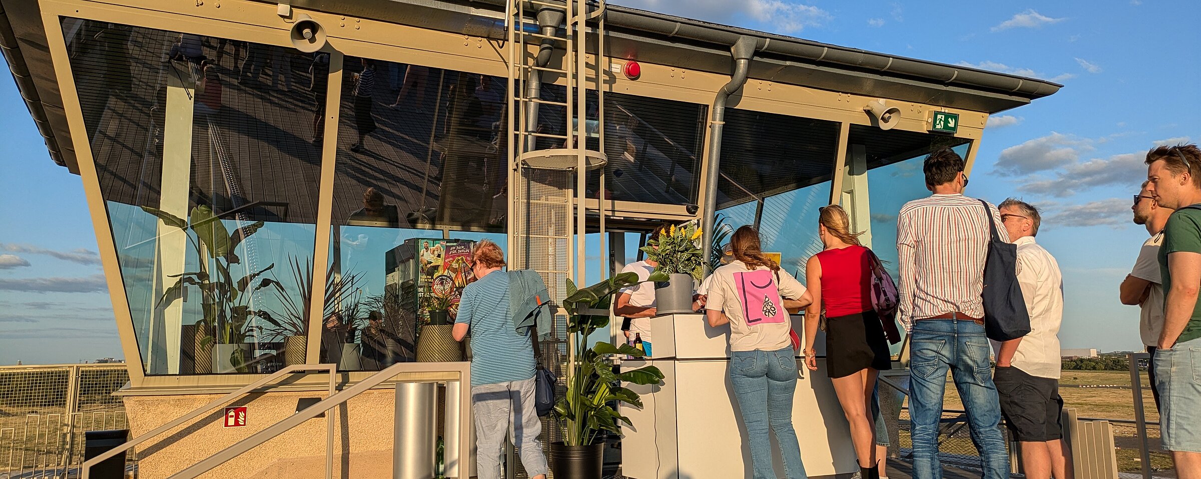 Ehemalige Fluglotsen Tower am Flughafen Tempelhof im Sommer. Menschen stehen in einer Schlange vor einer temporären Bar