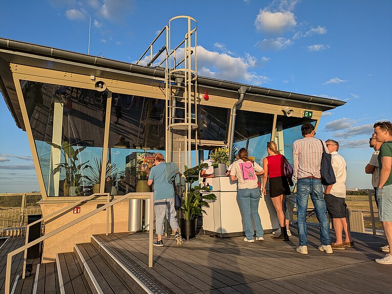 Ehemalige Fluglotsen Tower am Flughafen Tempelhof im Sommer. Menschen stehen in einer Schlange vor einer temporären Bar