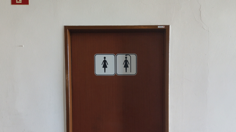 Braune Tür einer Toilette mit Mann und Frau Symbol