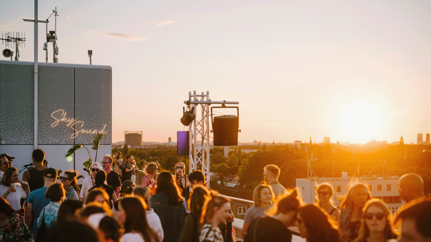 Menschen auf der Dachterrasse des THF TOWER beim Sonnenuntergang