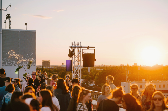 Menschen auf der Dachterrasse des THF TOWER beim Sonnenuntergang