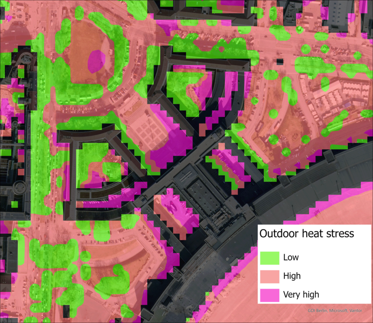 Eine farbcodierte Luftaufnahme eines Stadtgebiets zeigt Bereiche mit unterschiedlicher Outdoor-Hitzebelastung. Grün markiert niedrige, Orange hohe und Magenta sehr hohe Wärmebelastung. Gebäude, Straßen und Freiflächen sind klar erkennbar, wobei besonders dicht bebaute Zonen stärker betroffen sind.