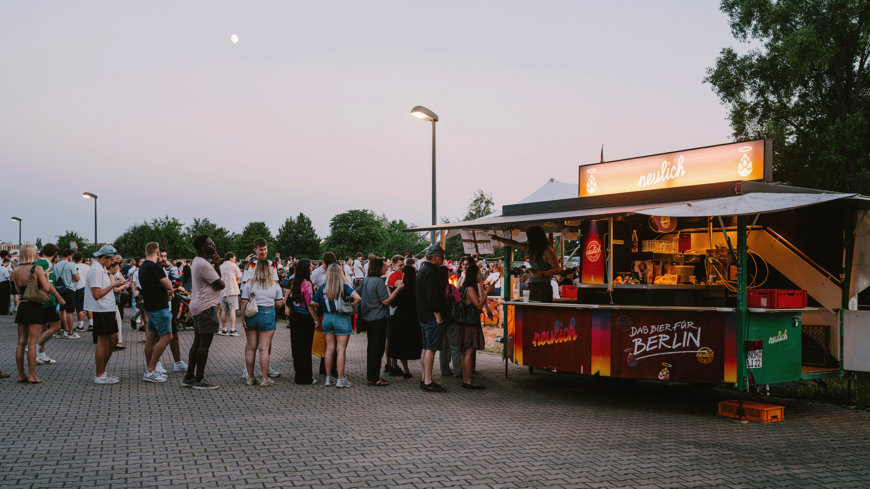 Menschen stehen im Neulich Biergarten Schlange 