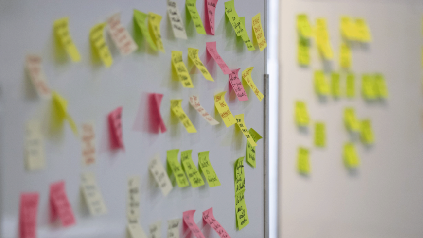 Eine Wand mit vielen bunten, beschrifteten Post-its