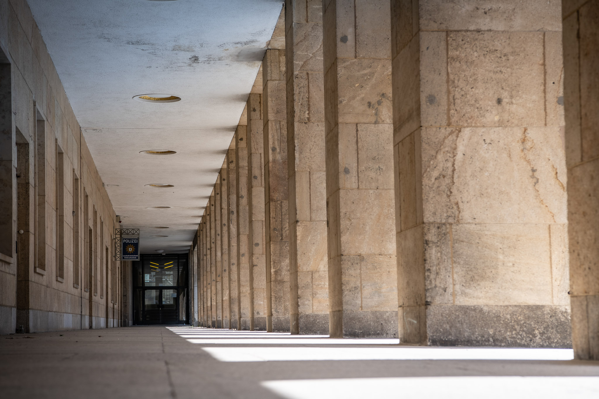 Blick durch einen Arkadengang am Ende ist eine dunkle Tür