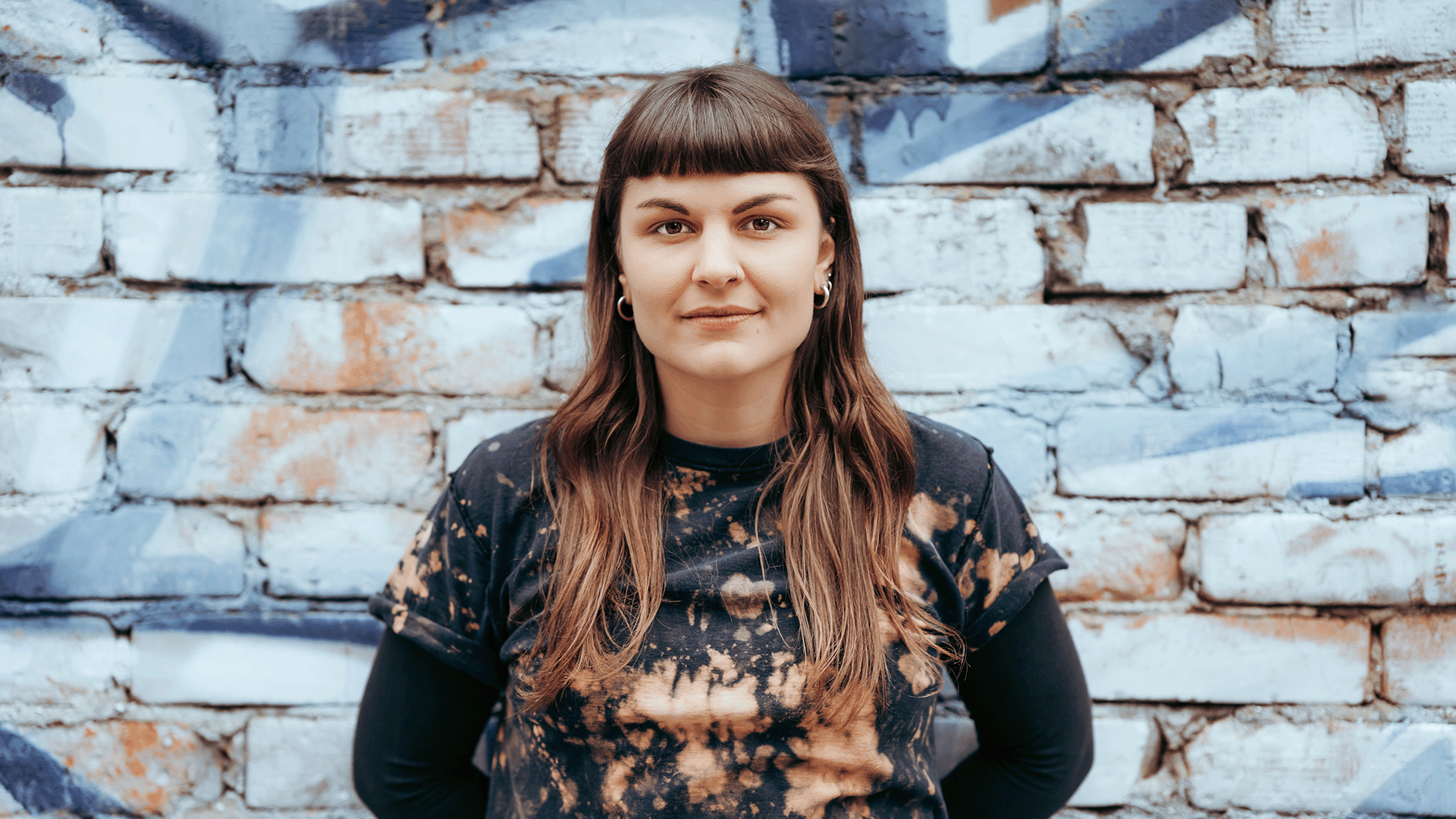 Porträt Foto von Susanne Siegert vor einer Steinmauer